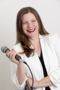 Personal Branding Photo - Smiling woman holding a microphone.