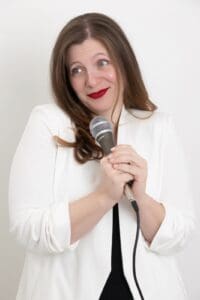 Personal Branding Photo - Smiling woman holding a microphone.