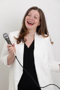 Personal Branding Photo - Smiling woman holding a microphone.